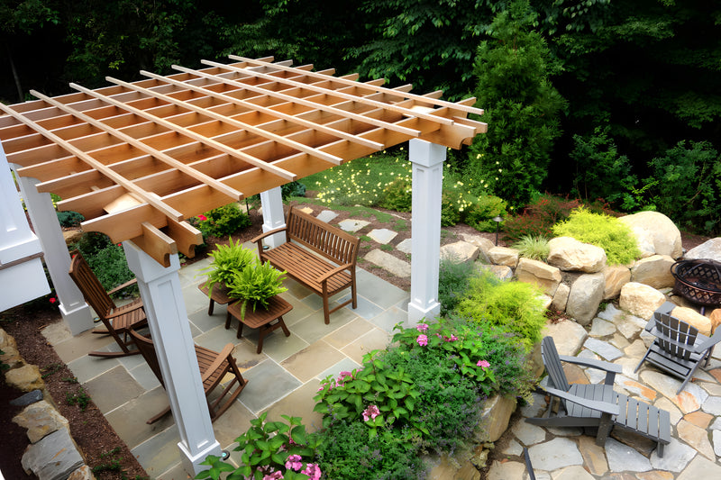 Outdoor patio with wooden pergola, chairs, and plants